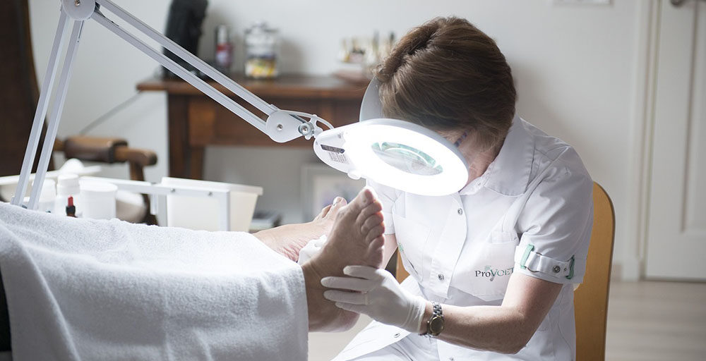 A doctor is examining the injuired foot