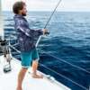 a man wearing fishing shirt on a boat