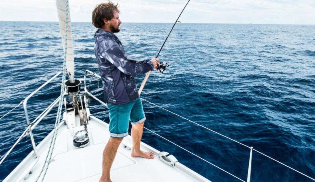 a man wearing fishing shirt on a boat