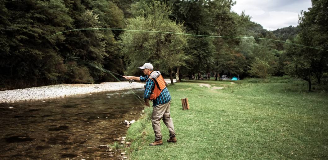 a fisherman is fly fishing in the lake